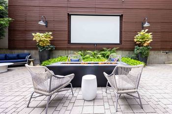 Two chairs are placed in front of a table with a white screen behind it.